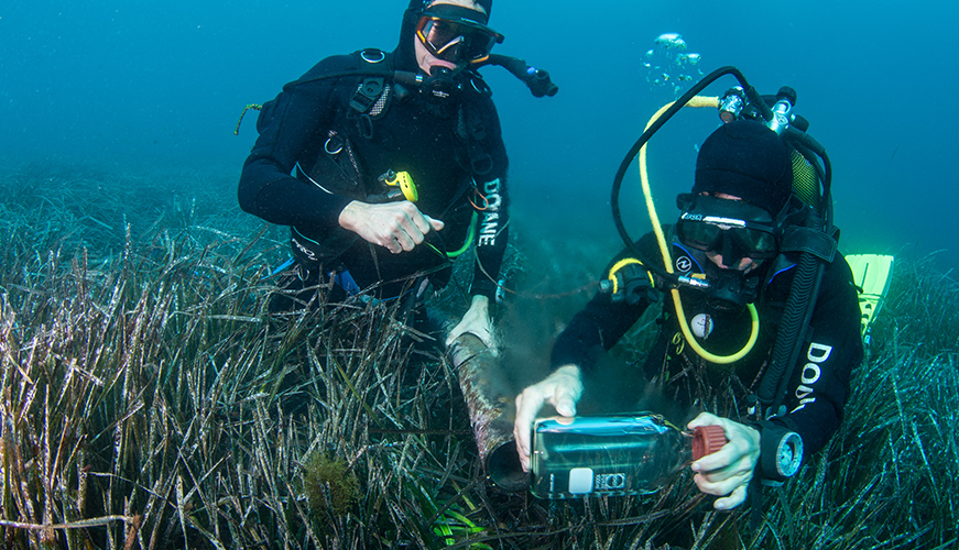 Deux plongeurs des douanes recueillent des échantillons d&#039;eau pour vérifier la pollution.